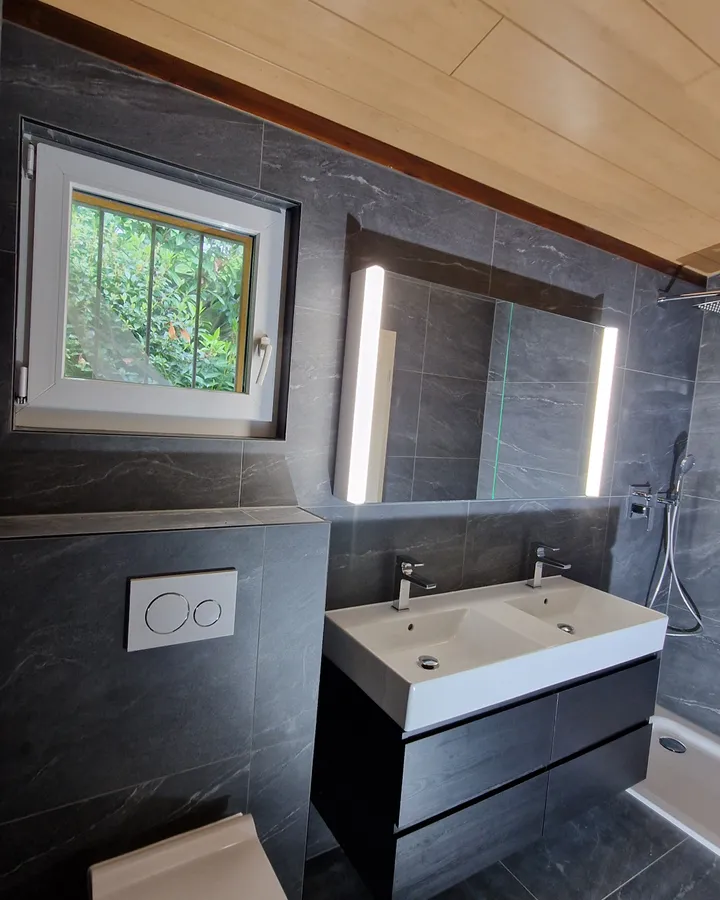 Salle de bains avec double vasque, miroir lumineux et douche