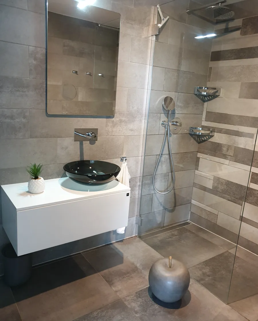 Détail de salle de bains avec miroir lumineux et finitions sanitaires